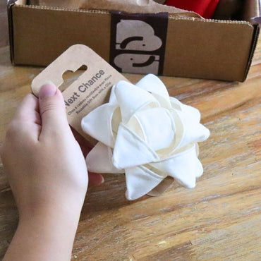 Le noeud à cadeau Next Chance sur son emballage recyclé