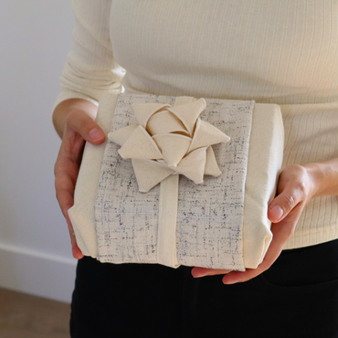 Reusable gift wrapping Vice-Versaᴷᴵᵀ - Cream wool blend band with navy blue thread on a cream Furoshiki and a cream gift bow