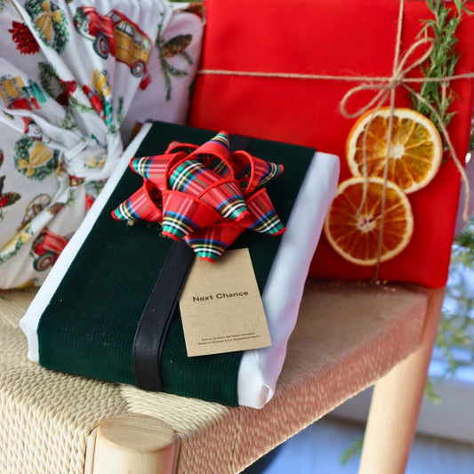 Reusable gift wrapping Vice-Versaᴷᴵᵀ - Forest green corduroy band on a white Furoshiki and a red and green tartan gift bow