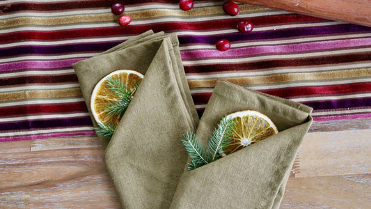 Serviettes de table pliées avec oranges séchées et chemin de table de Noël